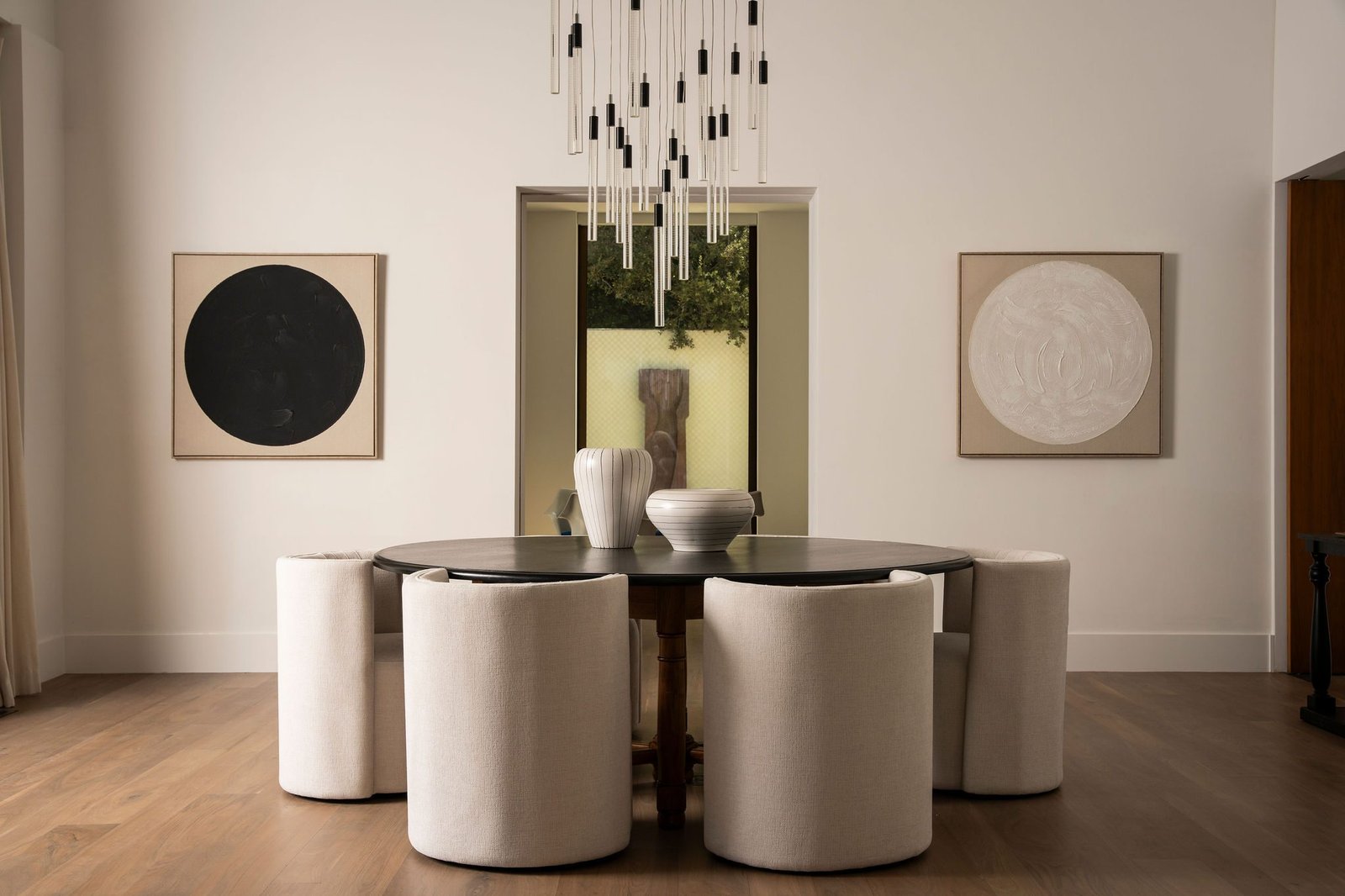 Dining room with a round table and a cluster of pendants