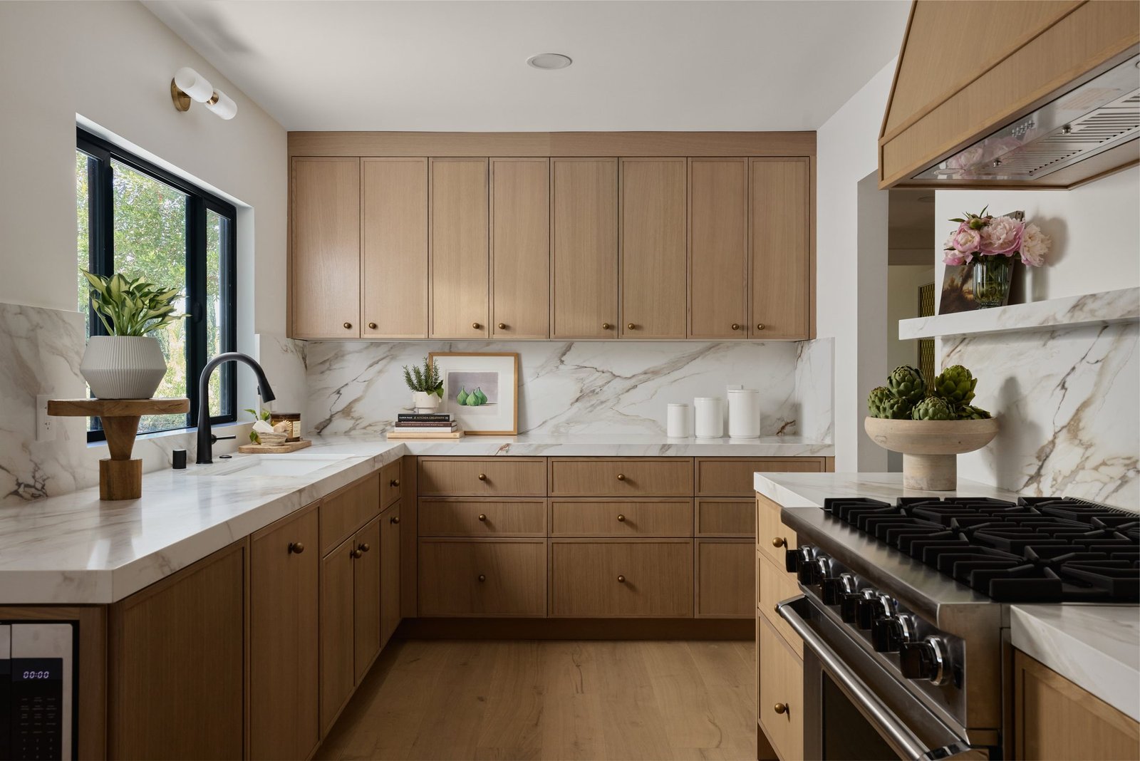 Kitchen with warm wood cabinetry and marble