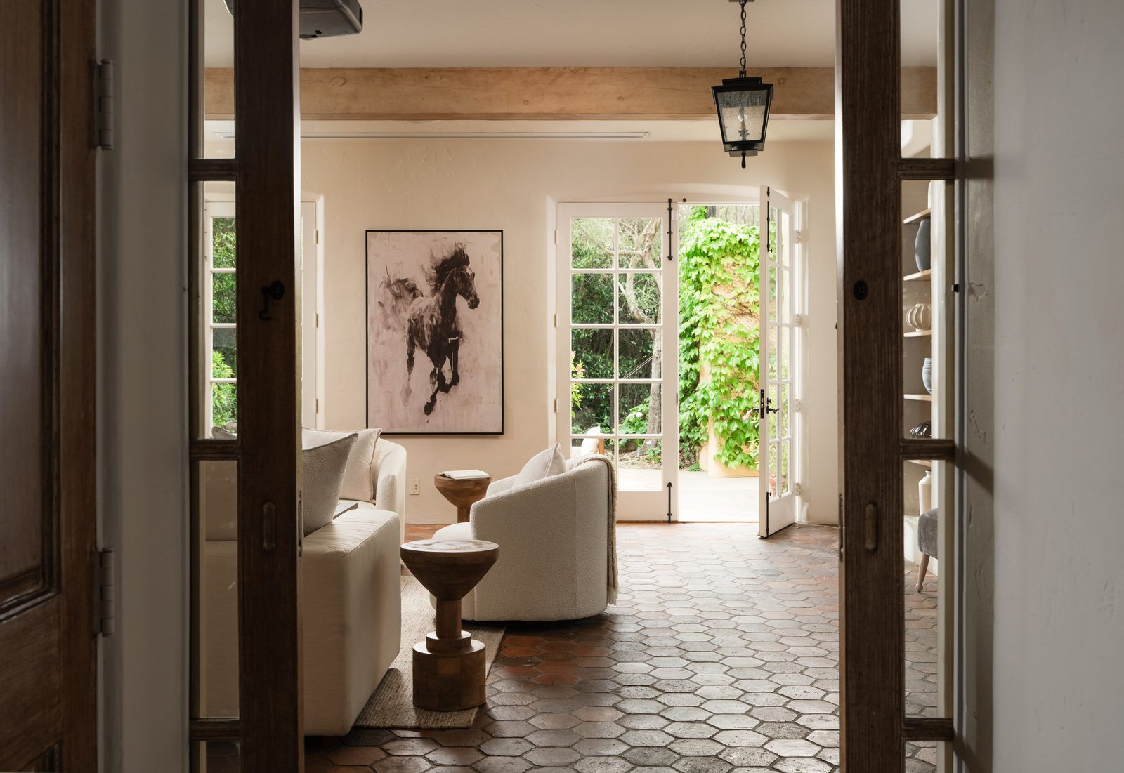 Sunlit living room with arched doorways and a garden view, designed by S & S Interiors