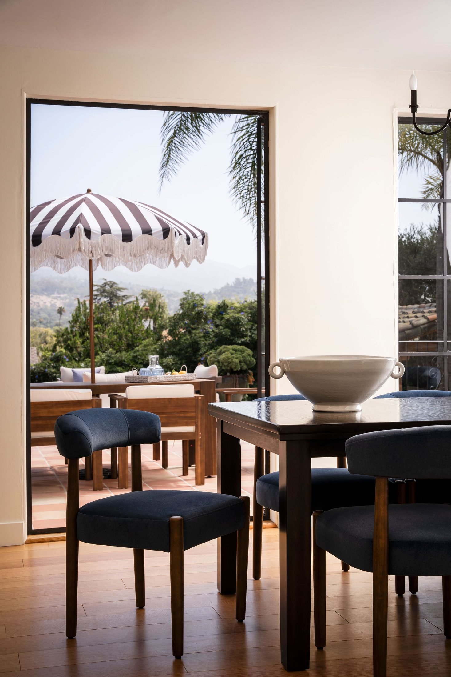 Outdoor dining terrace with a striped umbrella