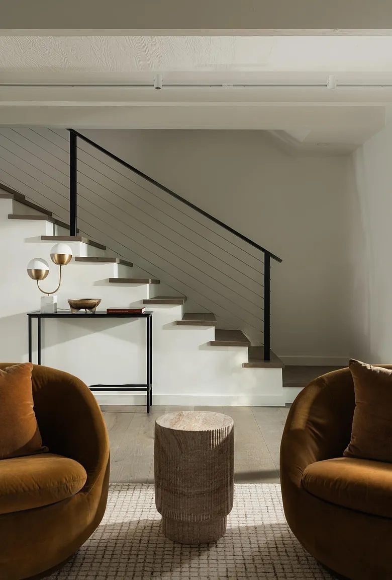 Staircase framed by a pair of gold accent chairs
